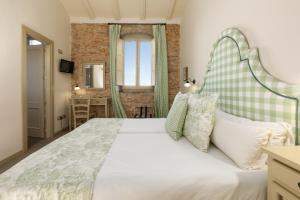 a bedroom with a large white bed and a window at Maison Muralleta B&B in Riba-Roja De Turia