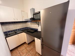 a small kitchen with a stainless steel refrigerator at LES VIEUX CABASSOLS VENELLES in Venelles