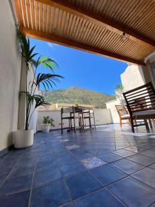 a patio with tables and chairs and a view of a hill at Atrium in Castellammare del Golfo