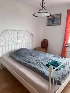 een slaapkamer met een wit bed en een blauwe deken bij Private studio apartment 13 min to Stockholm city in Sundbyberg