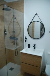 La salle de bains est pourvue d'une douche, d'un lavabo et d'un miroir. dans l'établissement Markesa, à Plasence