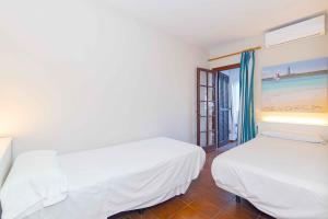 a white room with two beds and a window at Siesta Mar Private Apartment 83 Cala'n Porter 1 bed in Cala'n Porter