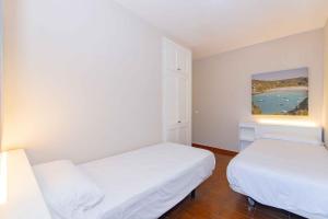 a room with two beds and a painting on the wall at Siesta Mar Private Apartment 83 Cala'n Porter 1 bed in Cala'n Porter