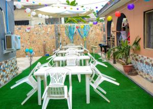 uma mesa e cadeiras num pátio com relva verde em Rehoboth hotel, Apartment and Event services em Suberu Oje