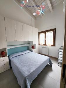 1 dormitorio con 1 cama con cabecero azul en A casa di Nala, en Tortoreto Lido