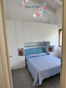 Schlafzimmer mit einem blauen Bett und weißen Schränken in der Unterkunft A casa di Nala in Tortoreto Lido
