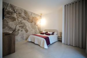 - une chambre avec un lit et une fresque murale dans l'établissement Agriturismo Ciriè, à Cassano delle Murge