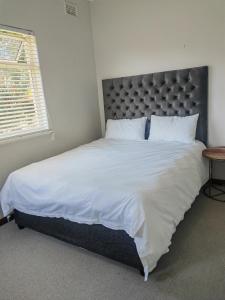 a bedroom with a large bed with white sheets and pillows at Entire specious 3 bedrooms house in Durban in Durban