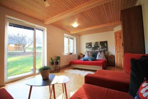 a living room with a red couch and a bed at Eden guest house in Brezno