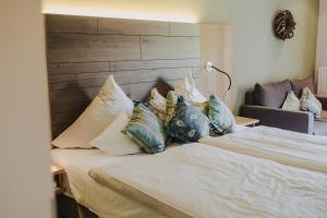 - une chambre avec un lit et des oreillers dans l'établissement Buchnas Landhotel Saarschleife, à Mettlach