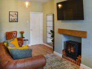 a living room with a couch and a fireplace at Hogarth Apartment By The Sea in Newbiggin-by-the-Sea