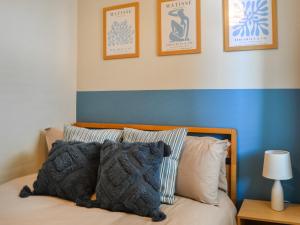 a bedroom with a bed with a blue and white wall at Hogarth Apartment By The Sea in Newbiggin-by-the-Sea