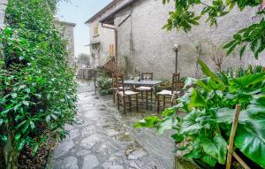 eine Terrasse mit einem Tisch, Stühlen und Pflanzen in der Unterkunft Lovely Apartment In Verni With Wifi in Verni
