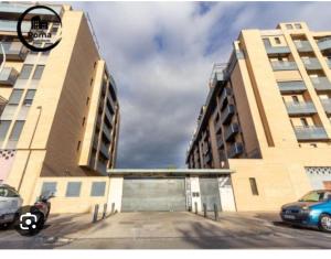 un gran edificio con coches estacionados en un estacionamiento en Acogedora habitación privada en Villa Mayka en Granada