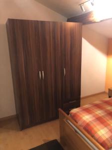 a bedroom with a large wooden cabinet next to a bed at Appartamento in Attico in Poschiavo