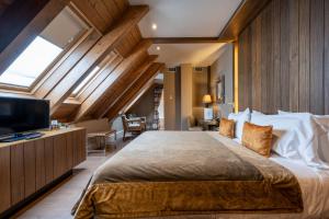 een slaapkamer met een groot bed en een televisie bij Hotel Val de Neu G.L. in Baqueira-Beret