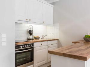 uma cozinha com armários brancos e um forno com placa de fogão em Skipper Hues em List