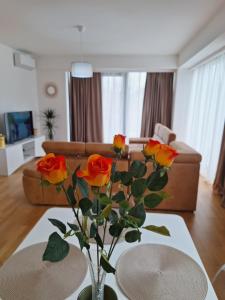a living room with a vase with roses on a table at Apartment Teodo magico in Tivat