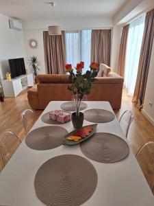 a living room with a table with flowers on it at Apartment Teodo magico in Tivat +7 photos