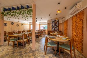 a restaurant with wooden tables and chairs at Click Hotel Mundra in Mundra