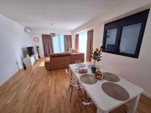 a living room with a white table and a couch at Apartment Teodo magico in Tivat