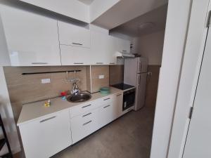 a white kitchen with a sink and a refrigerator at Apartment Teodo magico in Tivat