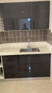 un bancone della cucina con lavandino e specchio di My5 Hotel a Kumasi