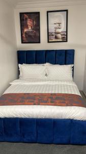 a bed with a blue headboard in a bedroom at My5 Hotel in Kumasi