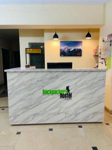 a large white counter with a sign on it at Backpackers Hostel Islamabad in Islamabad