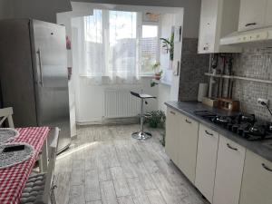 a kitchen with white cabinets and a counter top at Apartament Dodo in Cluj-Napoca