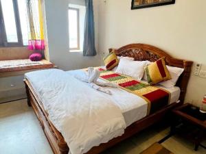 a bedroom with a large wooden bed with pillows at Ideal Guest House in Jaisalmer