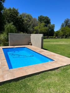 a swimming pool in a grassy yard with a wooden deck at Stoneridge in Oudtshoorn