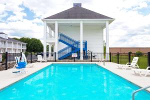 a swimming pool with chairs and a gazebo at Baymont by Wyndham Tullahoma in Tullahoma