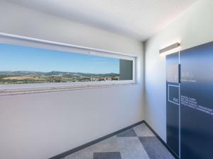 a room with a large window with a view at Hotel ibis Bragança in Bragança