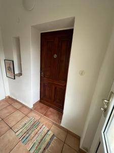 a hallway with a wooden door and a tile floor at Haus am Berzdorfer See in Görlitz