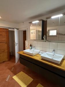 - une grande salle de bains avec deux lavabos et un miroir dans l'établissement Haus am Berzdorfer See, à Görlitz