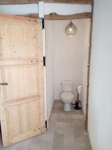 a bathroom with a toilet and a wooden door at Gîte Saint-Valéry-sur-Somme (gîte à la ferme) in Mons-Boubert +13 photos