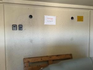 eine Wand mit einem Schild drauf mit einem Handy in der Unterkunft Apartment in Wels