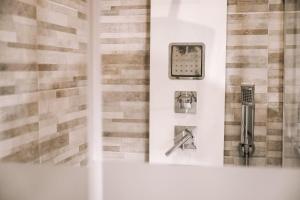 ein Badezimmer mit einer Dusche mit einer Uhr an der Wand in der Unterkunft Il vecchio salone in Lecce
