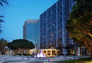 a large glass building with a fountain in front of it at Hyatt Regency Orange County in Anaheim