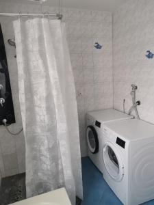 a washing machine in a bathroom with a shower curtain at Bob's Zimmer in Bielefeld