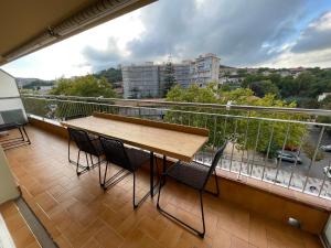 balcón con mesa y sillas de madera en Precioso apartamento céntrico con piscina, en S'Agaró