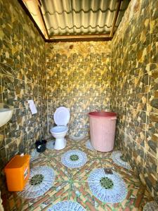 a tiled bathroom with a toilet and a sink at Ocamocam Beach Martins in New Busuanga