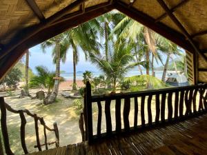 a view of the beach from the porch of a house at Ocamocam Beach Martins in New Busuanga