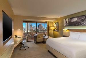 オースティンにあるハイアット リージェンシー オースティンのベッド付きのホテルルームで、市街の景色を望めます。