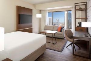 Cette chambre comprend un lit, un bureau et une télévision. dans l'établissement Hyatt Regency Phoenix, à Phoenix