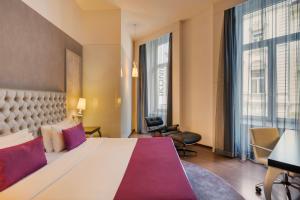 Habitación de hotel con cama grande y ventanas grandes. en Ikonik Parlament, en Budapest