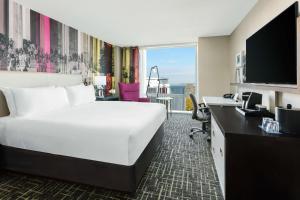 ein Hotelzimmer mit einem großen Bett und einem Schreibtisch in der Unterkunft Hyatt Centric Arlington in Arlington