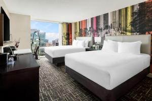 a hotel room with two beds and a television at Hyatt Centric Arlington in Arlington