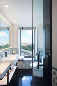 a bathroom with two sinks and a shower with a window at Hyatt Centric MG Road Bangalore in Bangalore